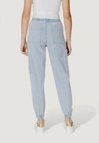 Pantaloni cargo de culoare albastru deschis, cu șnur în talie, cu manșete elastice și multiple buzunare, realizati dintr-un material moale și texturat. Design casual, potrivit pentru purtarea de zi cu zi.