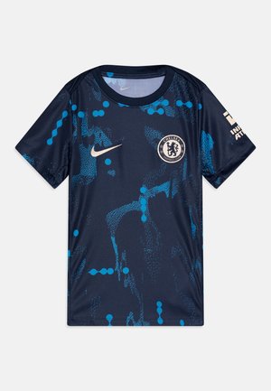Camiseta de fútbol azul marino con un patrón dinámico de puntos azules; presenta un cuello redondo, mangas cortas, el logotipo de Nike y el emblema del Chelsea FC.