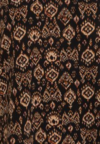 Svart tyg med ett detaljerat mönster av geometriska former och blommotiv i beige, guld och lila nyanser, med en strukturerad känsla.