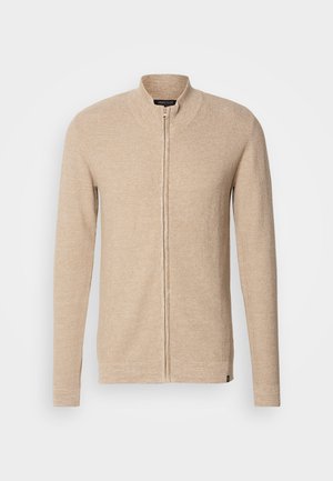 Cardigan bej cu fermoar și guler înalt, mâneci lungi, material tricotat texturat și accente subtile cu nervuri pe manșete și tiv.