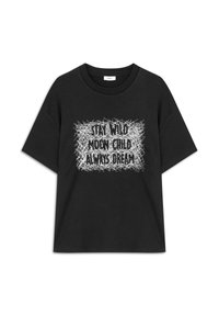 Camiseta de algodón negra de manga corta con un diseño gráfico en texto blanco: "MANTENTE SALVAJE HIJO DE LA LUNA SIEMPRE SUEÑA" sobre un fondo texturizado.
