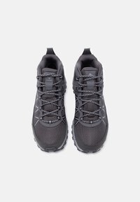 Ζευγάρι σκουρόχρωμα γκρι παπούτσια πεζοπορίας Columbia με ανακλαστικά κορδόνια και υφασμάτινο δίχτυ, που βλέπουμε από πάνω σε λευκό φόντο.