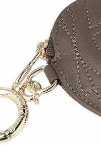 Portachiavi portafoglio rotondo in pelle grigia con motivo trapuntato e ferrature color oro. Dotato di chiusura con cerniera e anello portachiavi in metallo.