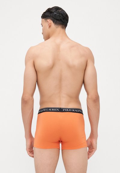Boxer aderenti arancioni con un elastico nero su cui è stampato "POLO RALPH LAUREN" in bianco. Realizzati in un tessuto morbido e elastico per garantire comfort.