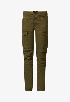 Garçon portant un t-shirt jaune clair, un pantalon cargo vert olive et des baskets blanches, debout avec une main dans la poche.