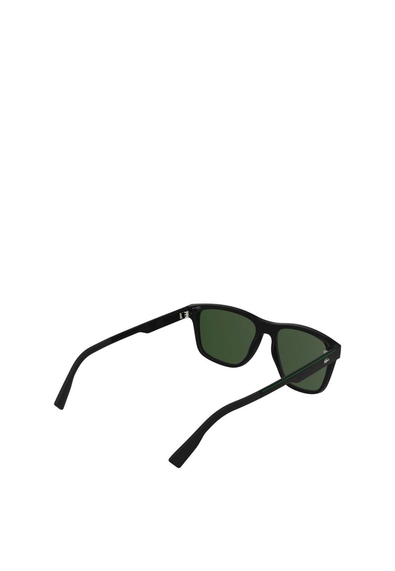 Lunettes noires avec des verres verts. Monture carrée avec une finition mate. Les branches fines présentent un subtil accent vert.