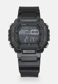 Digitális óra négyzet alakú fekete tokkal és gumiszíjjal. Jellemzői közé tartozik a fekete LCD kijelző, gombok és a "WR 100M" felirat a vízállóság érdekében.