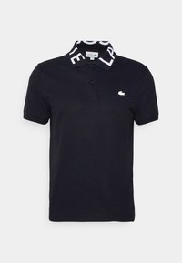 Czarna koszulka polo z wzorzystym kołnierzykiem z nazwą marki, dwoma guzikami z przodu oraz małym białym logo na klatce piersiowej. Wykonana z materiału bawełnianego.