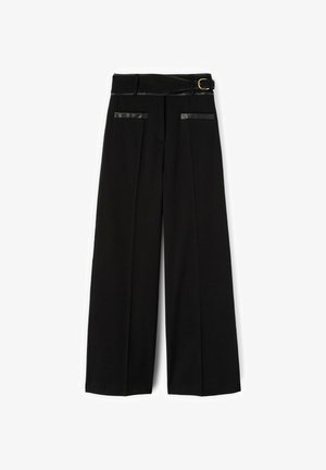 Pantalon large noir à taille haute, plis devant, deux poches bordées de cuir et une ceinture assortie avec une boucle dorée.