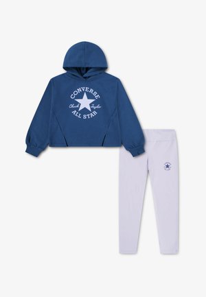 Sininen hupullinen collegepaita, jossa valkoinen "Converse All Star" -painatus, ja sitä täydentävät vaaleanvioletit leggingsit, joissa on logo lahkeessa. Puuvillasekoitekangas.