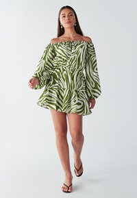 Õlgadeta minikleit roheliste ja valgete sebratriipudega, millel on vöökoht, balloonlõikelised varrukad ja kihiline volangiline ääreline.