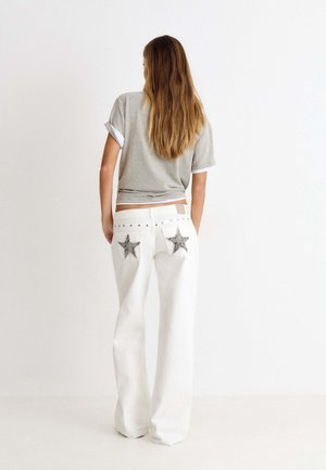 Brownie, PANTALÓN TIRO BAJO ESTRELLAS GLITTER Y TACHAS - Straight leg jeans - blanco