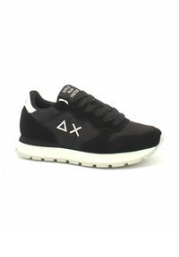 Scarpe sportive nere in suede e mesh, con una suola bianca, logo triangolare e testo "LE RAGAZZE CORRONO PIÙ VELOCI" sulla linguetta.