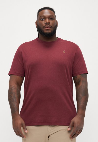 Bordeauxrotes Kurzarm-T-Shirt aus weichem Baumwollstoff. Mit Rundhalsausschnitt und kleinem Logo auf der linken Brust. Glatte Textur.