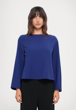 Maglietta a maniche lunghe blu navy con scollo a barca e vestibilità rilassata. Realizzata in un tessuto liscio, presenta un orlo leggermente cropped e dettagli minimi.