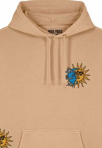 Beige huvtröja med framficka, prydd med en sol- och mångrafik i gult och blått. Texten "MIRA PARIS" finns inuti huvan.