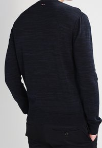 Maglione lavorato a maglia blu navy con motivo testurizzato, polsini e orlo a costine e piccolo logo sul retro del collo.