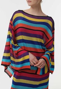 Multicolored gebreid top met gedurfde horizontale strepen in rood, blauw, geel, oranje en zwart; losse pasvorm met brede mouwen en een textuurstof.