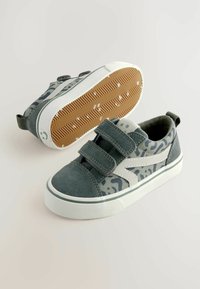 Szare zamszowe sneakersy w kamuflażowym wzorze, z podwójnymi zapięciami na rzepy, białą gumową podeszwą oraz teksturowaną brązową podeszwą.