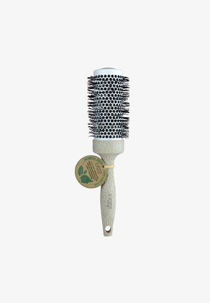 Brosse thermique ronde avec des poils noirs, un cylindre blanc à trous hexagonaux et un manche beige texturé avec une étiquette attachée.