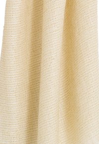 Tela texturizada en beige claro con un patrón tejido. El material parece suave y ligeramente lustroso, lo que realza su interés visual.