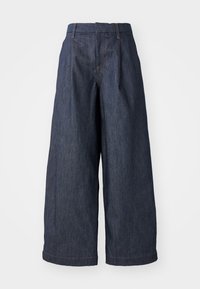 Pantalones de mezclilla anchos de color azul oscuro con cintura alta, que presentan pliegues en la parte delantera y un dobladillo que cae justo por encima del tobillo.