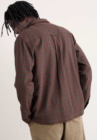 Bruine en groene geruite overhemd met lange mouwen en een kraag, voorzien van een plooitje in het midden van de rug en knoopmanchetten, gemaakt van gestructureerde stof.