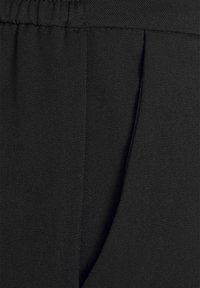 Zwart stof met een gladde textuur, met een plooidetail en een elastische tailleband voor comfort. Geschikt voor verschillende casual situaties.