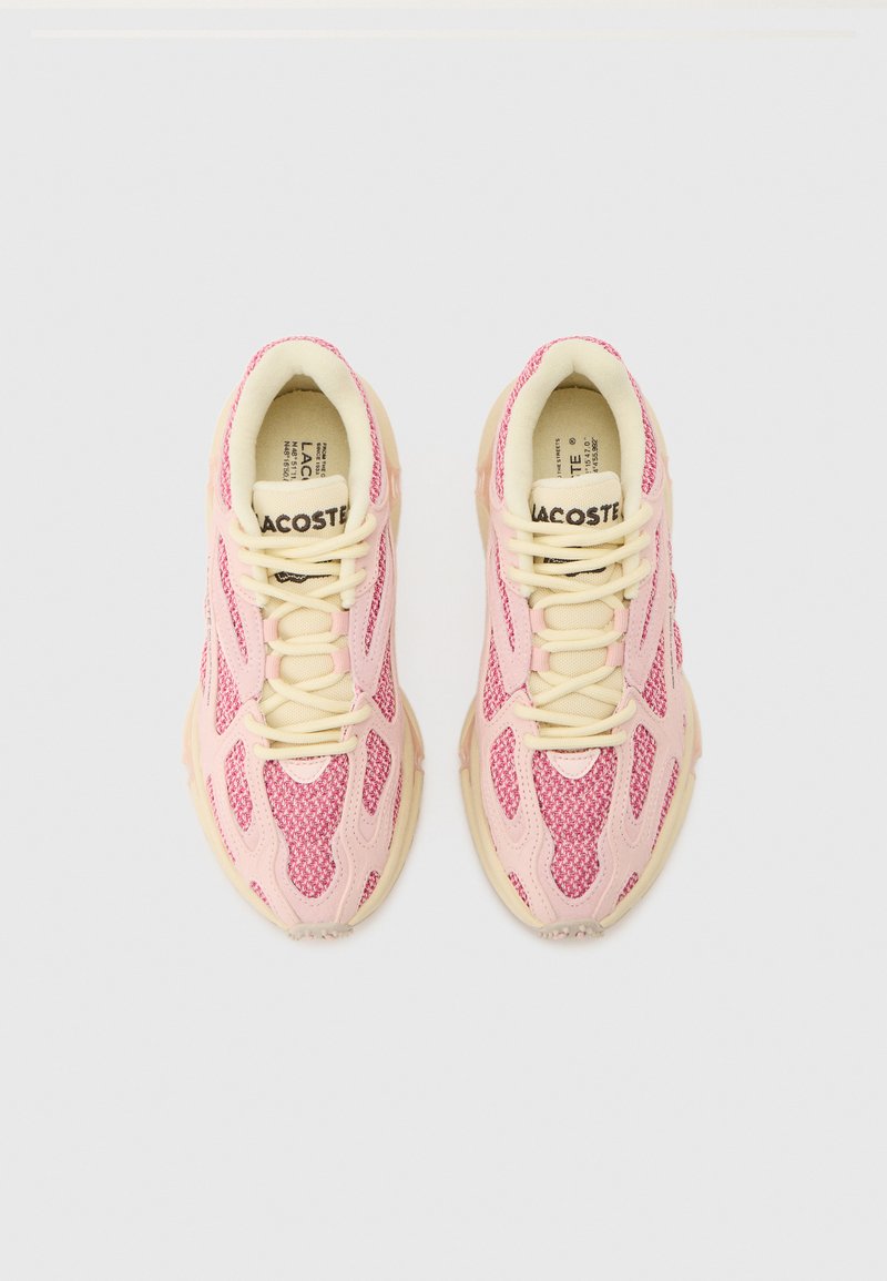 Pair of pink and cream Lacoste sneakers with mesh and leather panels, cream laces, and branded tongues, viewed from above on a white background.