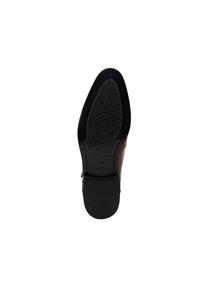 Suela de zapato de cuero marrón con una base de goma negra texturizada y un ligero tacón. Parte superior lisa con costuras detalladas a lo largo de los lados.