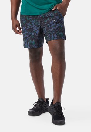 Shorts i ett mörkt, flerfärgat mönster med gröna och blåstänk. Lättviktsmaterial och standardpassform. Matchat med svarta sneakers.
