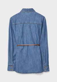 Camicia di denim leggera blu con maniche lunghe, colletto e polsini abbottonati. Una cintura in pelle marrone accentua la vita.