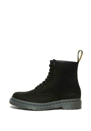 Bottine noire en cuir à lacets avec une semelle grise épaisse et une languette jaune au talon.