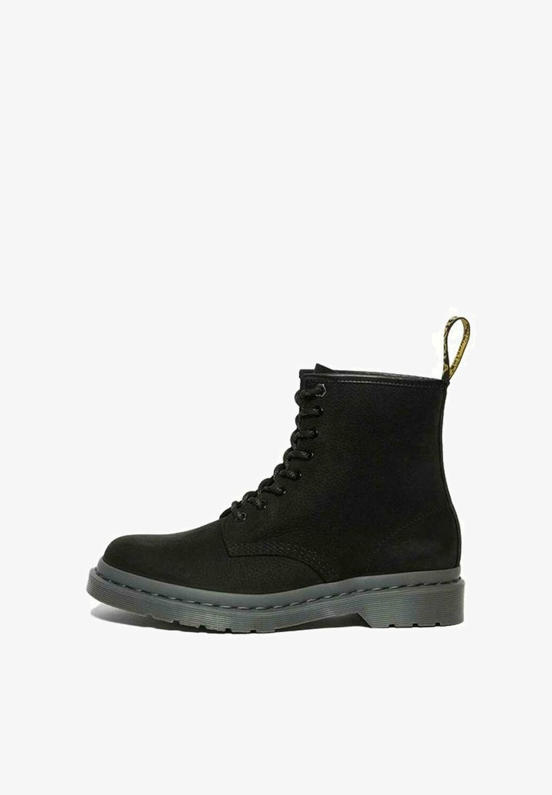 Bottine noire en cuir à lacets avec une semelle grise épaisse et une languette jaune au talon.