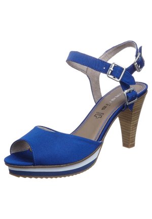 Blå stofsandaler med åben tå, rem omkring anklen, sølvspænder og en stablet hæl, med en hvid og blå lagdelt platform.