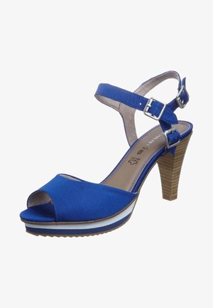 Niebieskie sandały z otwartym noskiem, pasek wokół kostki, srebrne klamry i obcas na platformie z warstwami białych i niebieskich elementów.