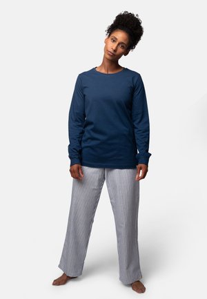 Marineblauwe lange mouwen shirt met ronde hals, gecombineerd met grijs-witte gestreepte pyjamabroek. Katoenen stof met een ontspannen pasvorm.