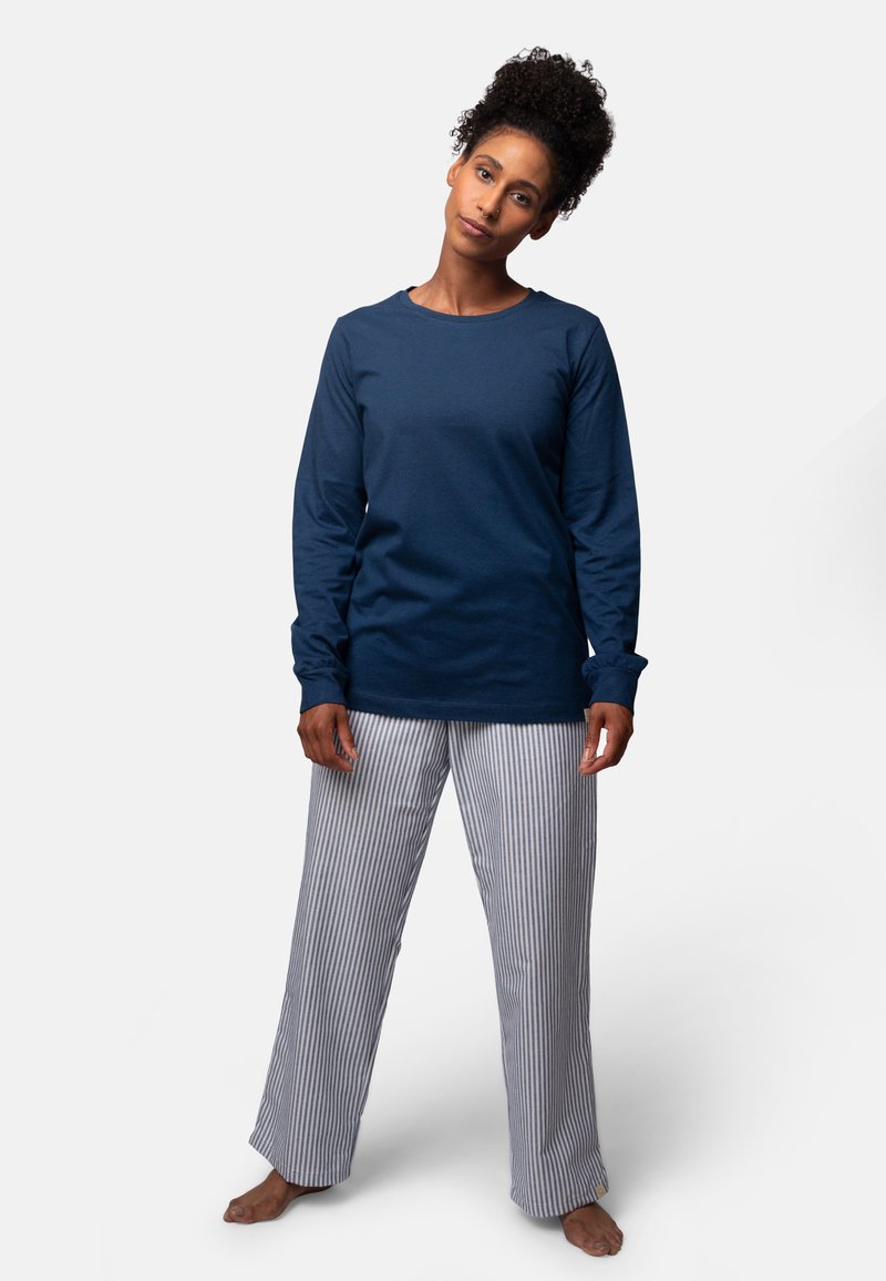 Marineblauwe lange mouwen shirt met ronde hals, gecombineerd met grijs-witte gestreepte pyjamabroek. Katoenen stof met een ontspannen pasvorm.
