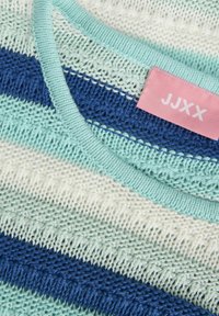 Randig stickad tröja i ljusblått, mint och marinblått, med en texturerad design, ribbad halsringning och en rosa etikett med texten "JJXX."