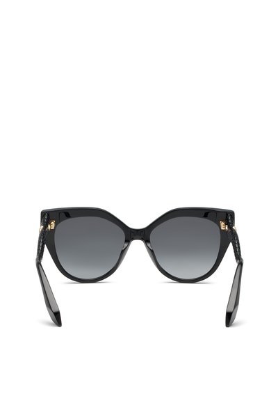 Lunettes de soleil « œil de chat » noires avec verres foncés dégradés et branches texturées reposant ouvertes sur une surface blanche.