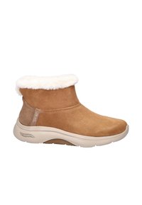 Bruine suède enkelboot met een witte nepbontkraag, een gevoerde beige zool en een logo detail aan de zijkant. Heeft een ronde neus en een zachte textuur.