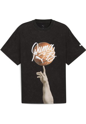 T-shirt in cotone nero con grafica di una mano che bilancia un pallone da basket. Il logo bianco "Puma" e gli accenti della maglietta evidenziano il design.