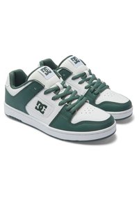 Green and white sneakers featuring a leather and synthetic upper, round toe, lace-up design, punctured detailing, and DC logo accents.
