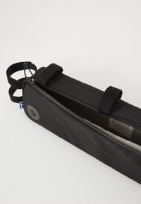 Trousse en tissu noir avec fermeture éclair, sangles Velcro et logo circulaire. Comprend une petite étiquette d'accent bleu et jaune.