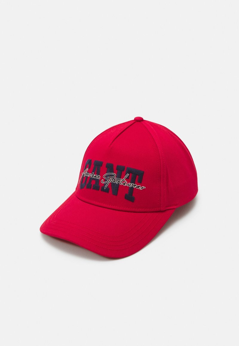 Casquette de baseball rouge avec des lettres noires en gras formant le mot "GANT" et un texte blanc en cursive "American Sportswear" sur le panneau avant.