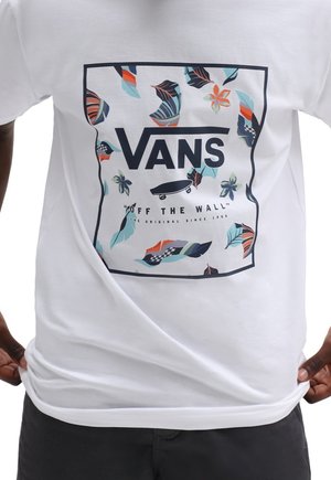 Hvid t-shirt med et farverigt Vans-logo og tropiske bladmønstre samt blomster. Rund hals, korte ærmer, glat bomuldsstruktur.