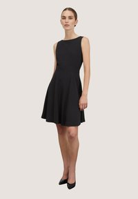 Schwarzes ärmelloses Kleid mit tailliertem Oberteil und ausgestelltem Rock. Glatter, leichter Stoff mit einer klaren, klassischen Silhouette.