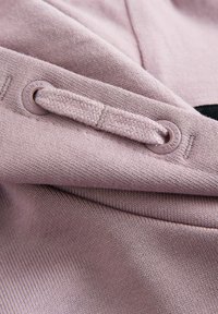 Gros plan sur un sweat à capuche en tricot mauve avec un cordon passé à travers des œillets ronds embossés du texte "ALLSAINTS."