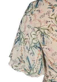 Tissu à motif floral avec des couleurs pastel douces sur un fond clair ; manches évasées avec une finition texturée subtile.