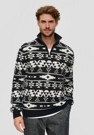 Schwarzer und weißer Pullover mit Muster und hohem Kragen, ausgestattet mit geometrischen Designs und einem Reißverschluss, aus weichem Strickstoff gefertigt.